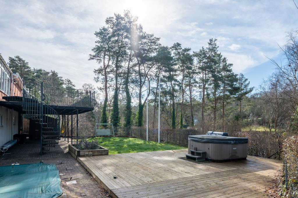 Lot: 164 - THREE-BEDROOM HOUSE IN SECLUDED LOCATION OVERLOOKING WOODLAND - Decking area with hot tub looking towards trees